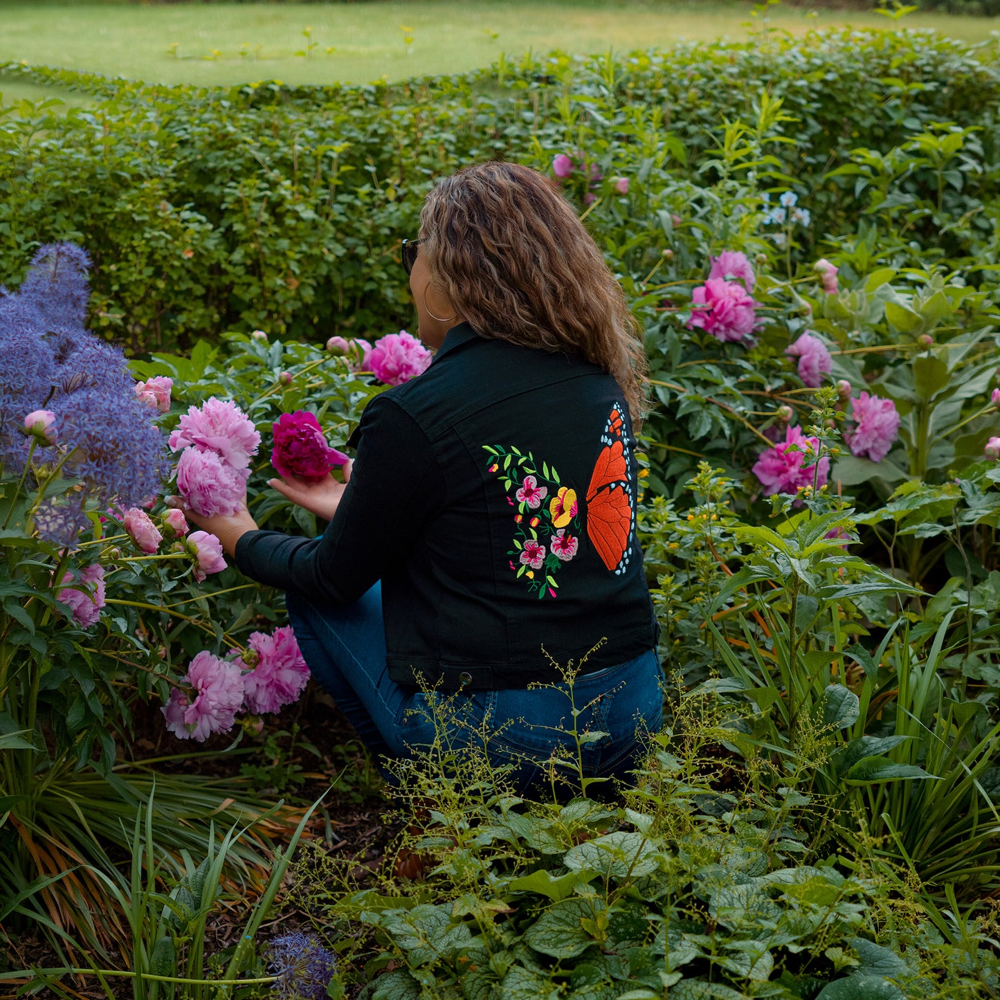 Black denim jacket with monarch butterfly embroidery and colorful floral artisan details