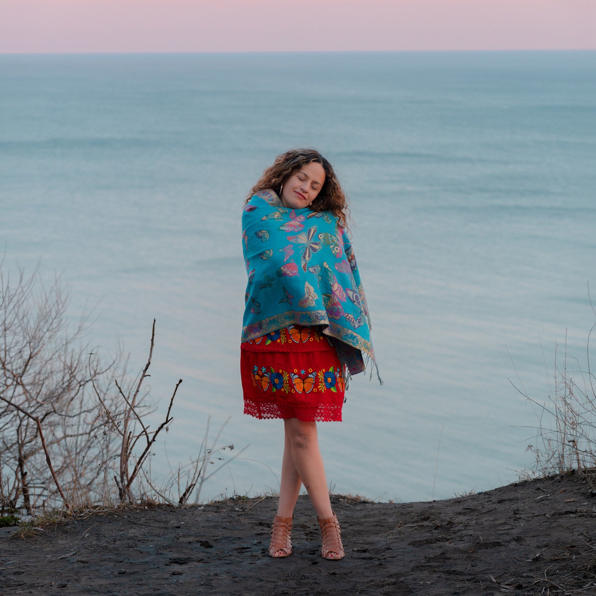 turquoise monarch butterfly reversible shawl worn by woman near lake at sunset
