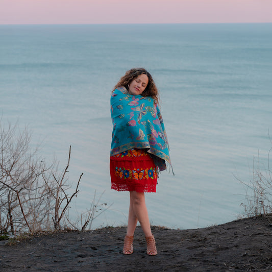 turquoise monarch butterfly reversible shawl worn by woman near lake at sunset