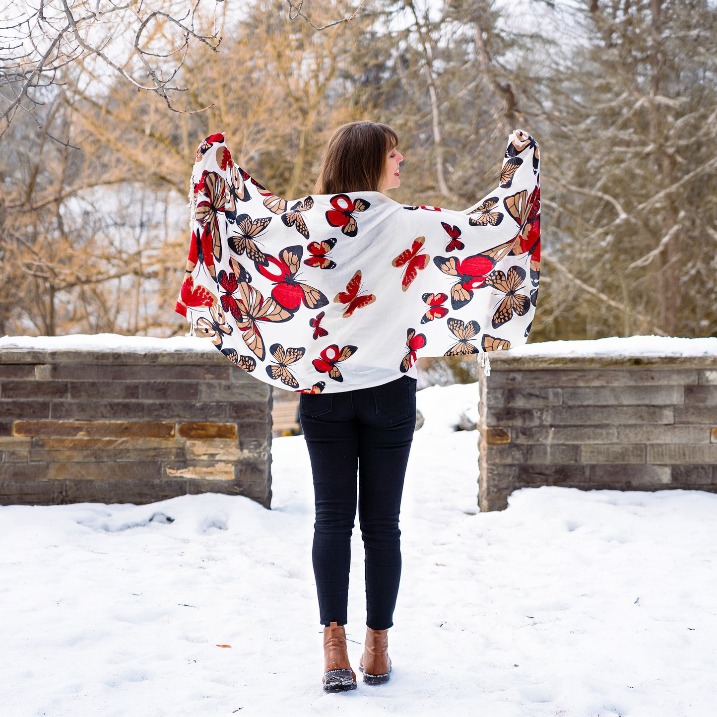 White reversible shawl with red monarch butterfly design worn outdoors