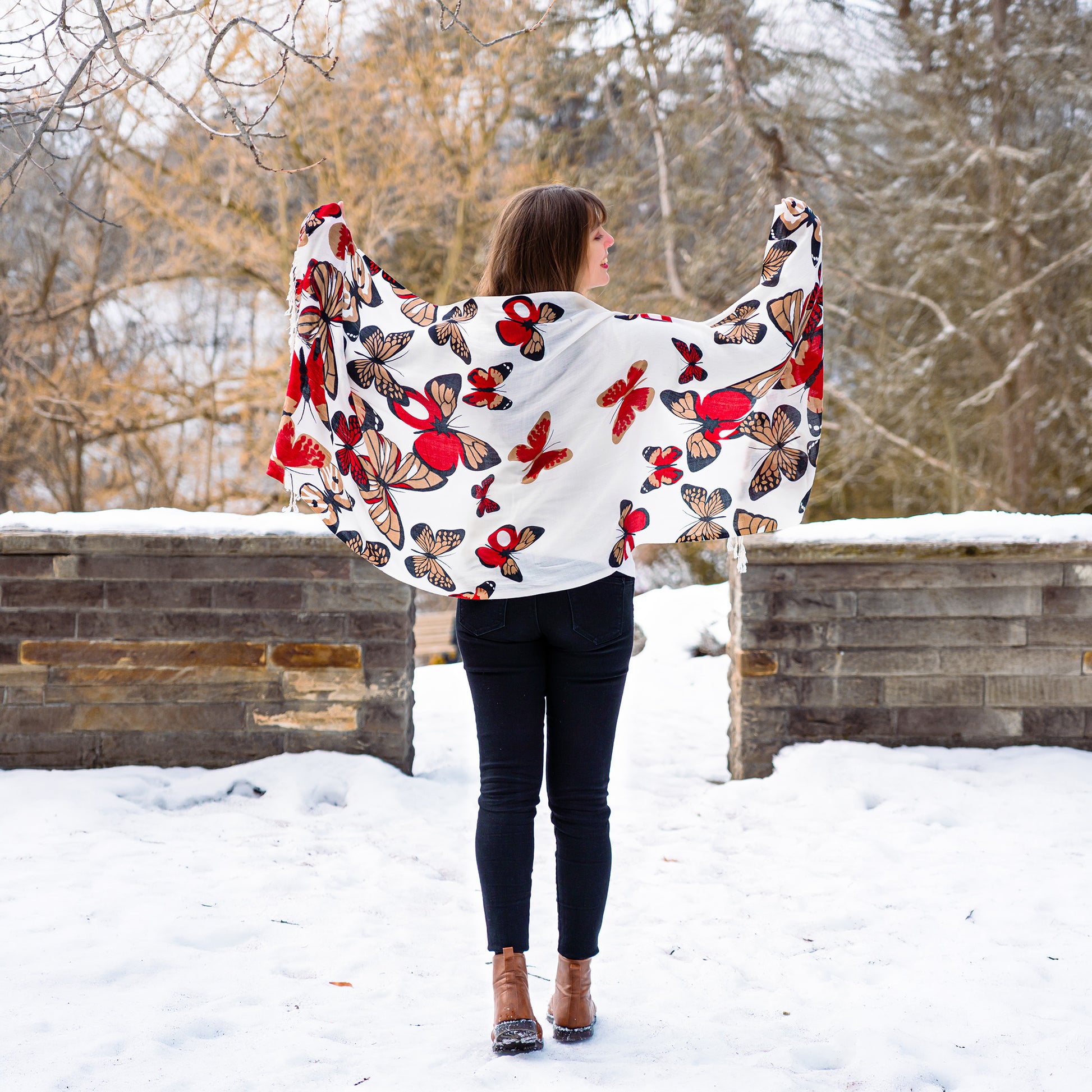 White reversible shawl with red monarch butterfly design worn outdoors